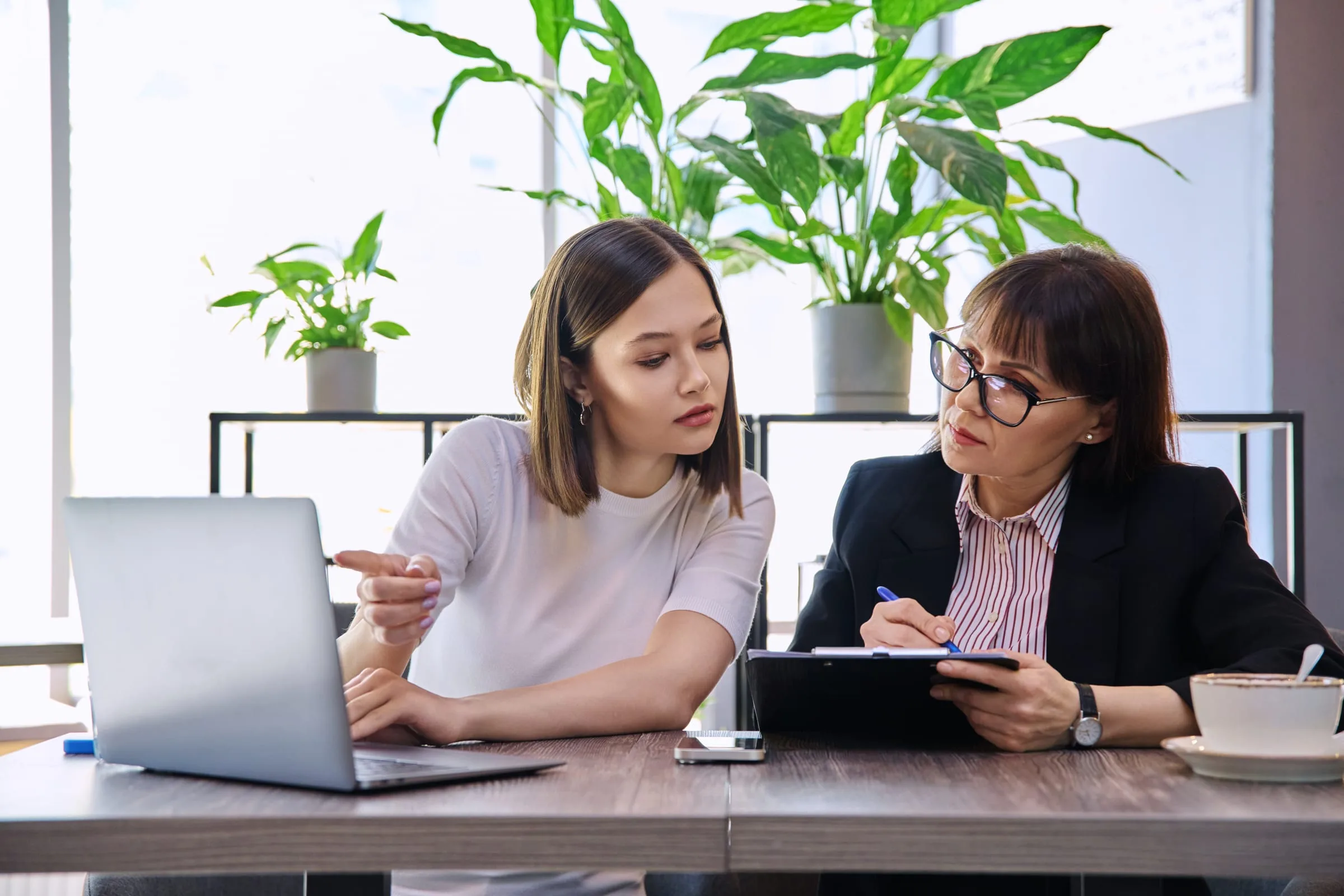 Vrouw met laptop en aantekeningen